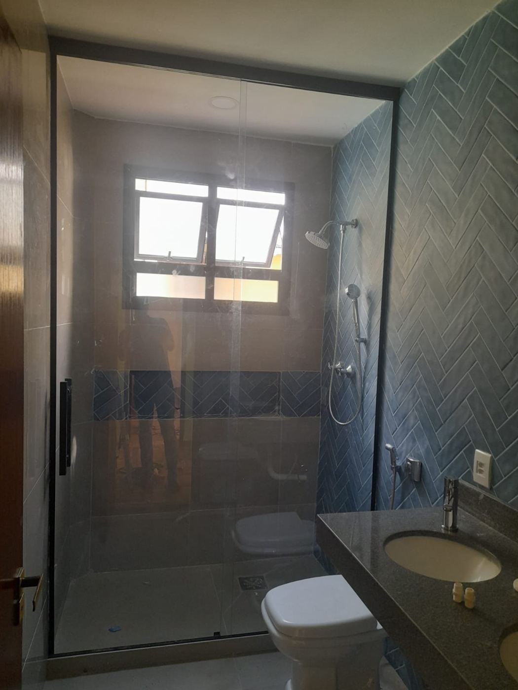 Box de vidro com perfil preto em banheiro de azulejo azul