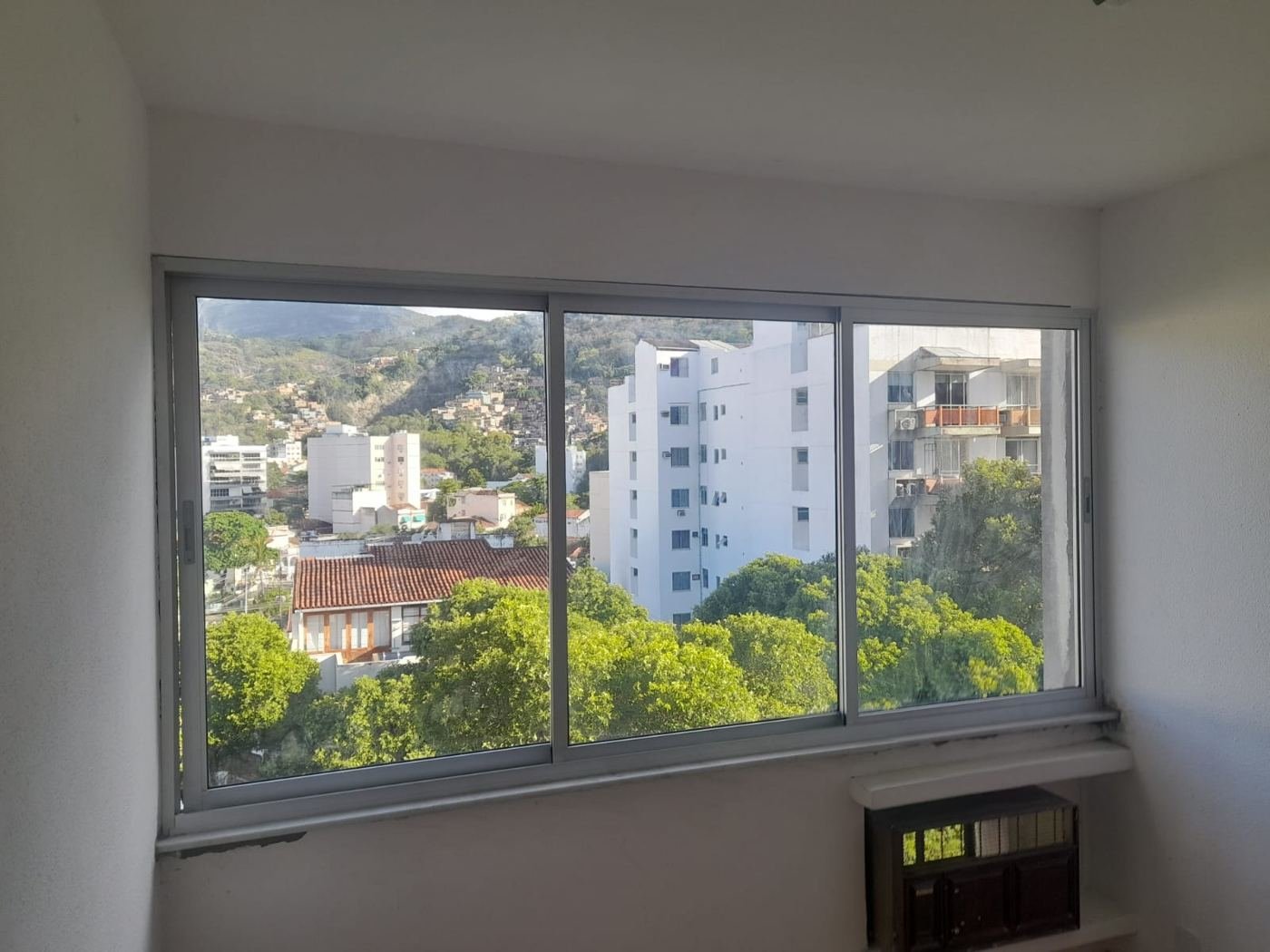 Janela de correr branca de três folhas em quarto