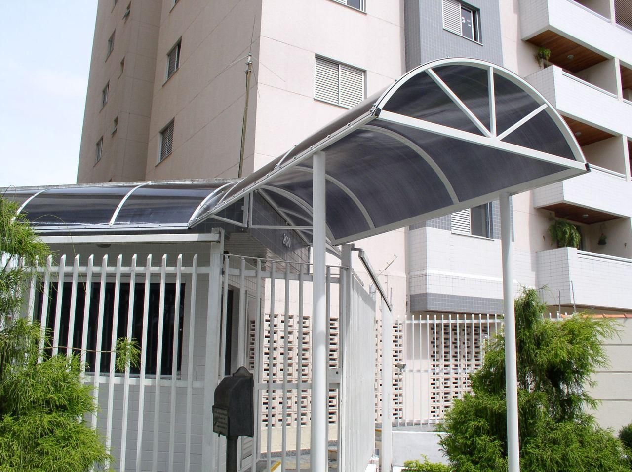 Marquise curva de policarbonato na entrada de um prédio